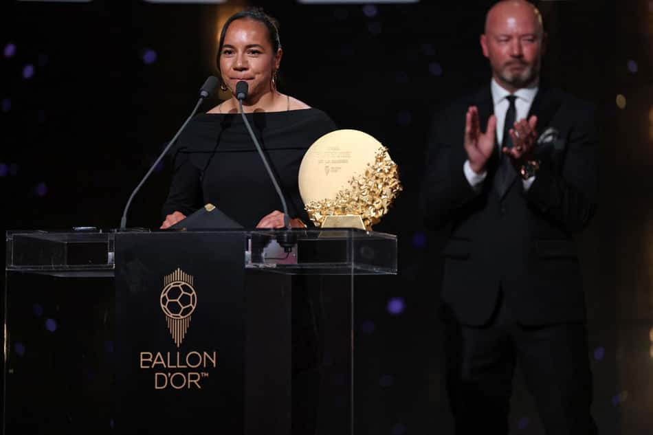 Charlyn Corral no palco recebendo o Ballon d'Or, com aplausos ao fundo.