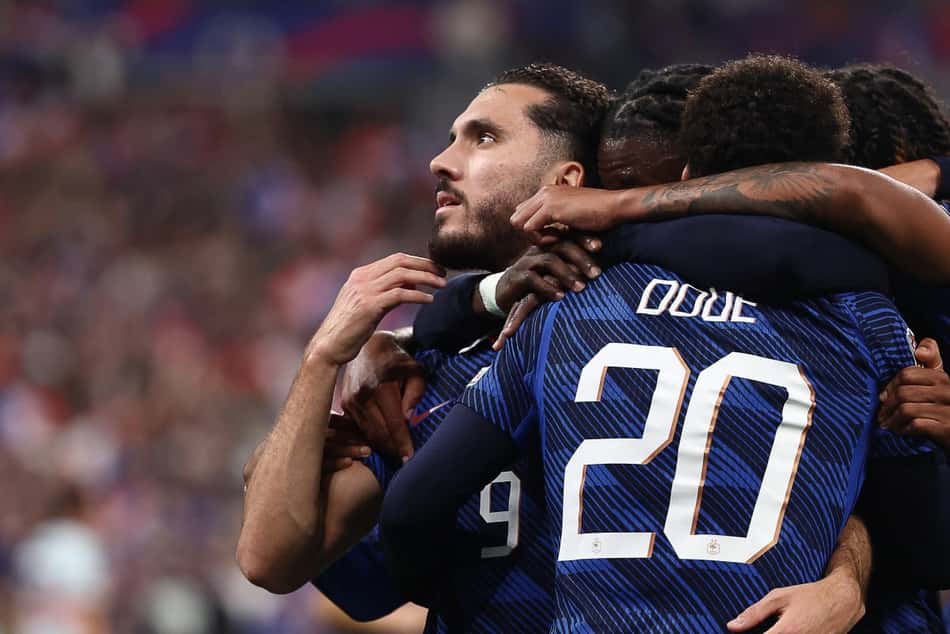 Cherki (e) é abraçado ao fazer o gol da virada da França sobre a Bélgica