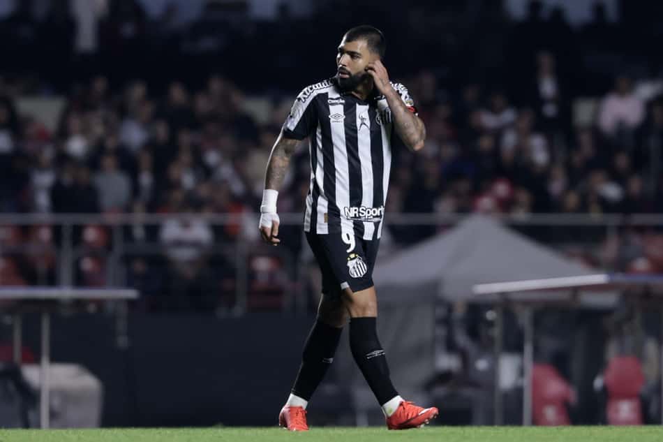 Gabigol com a mão rosto com a camisa do Santos