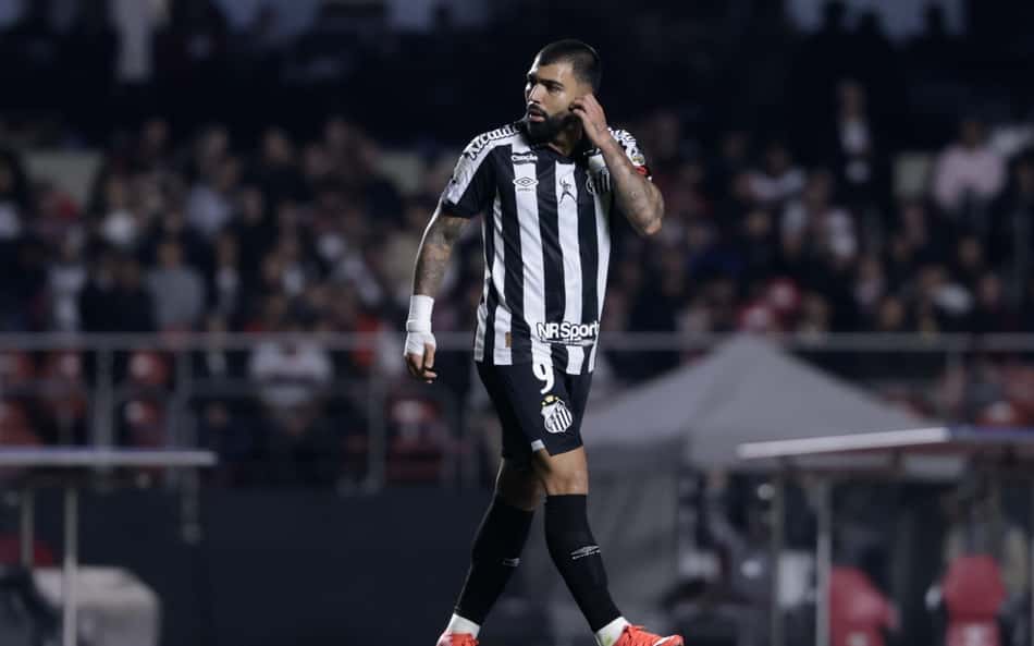 Gabigol com a mão rosto com a camisa do Santos