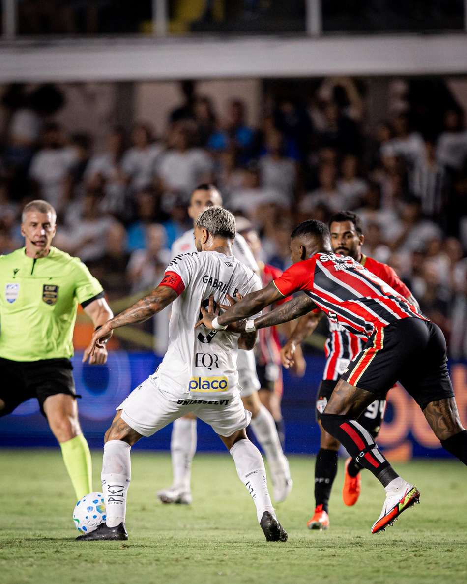 Gabigol sofre a marcação de um jogador do São Paulo na partida contra o Santos no primeiro turno do Brasileirão