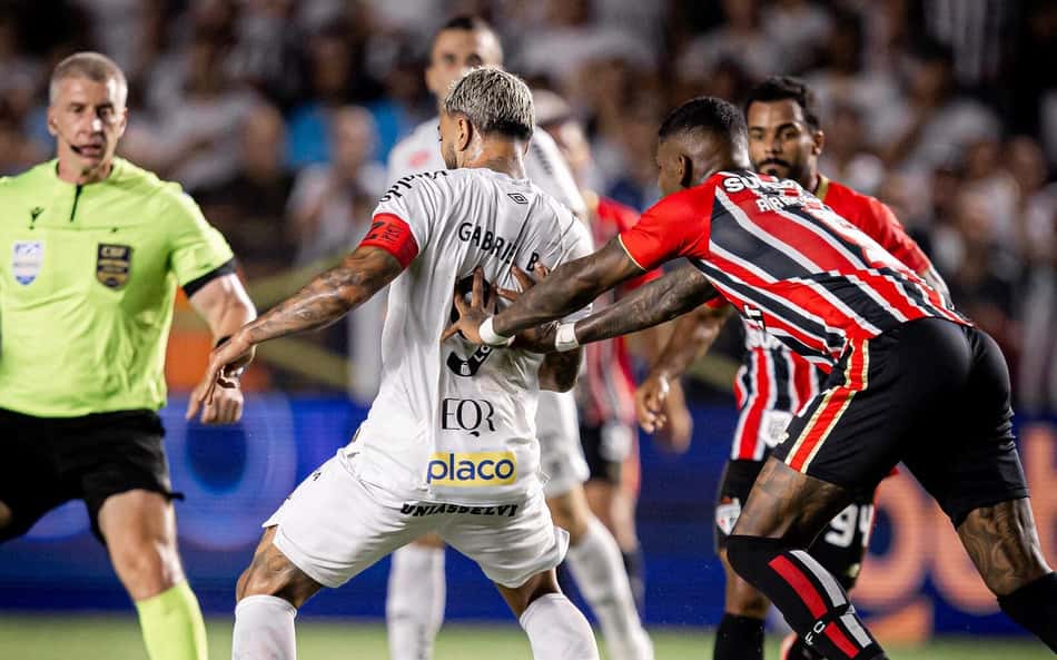 Gabigol sofre a marcação de um jogador do São Paulo na partida contra o Santos no primeiro turno do Brasileirão