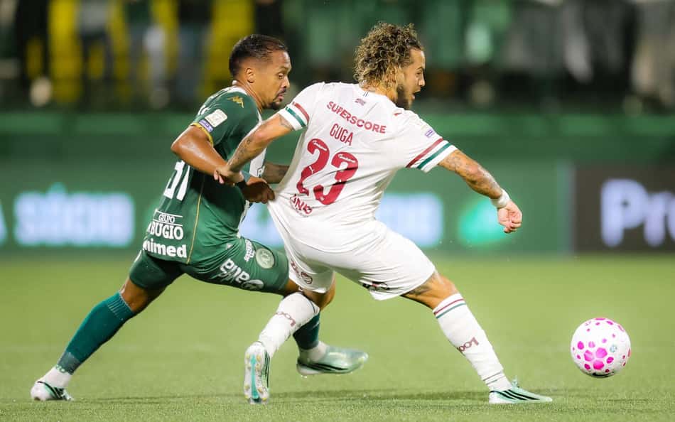 Guga (Fluminense) disputa a bola com jogador do time verde; bola rosa em campo.