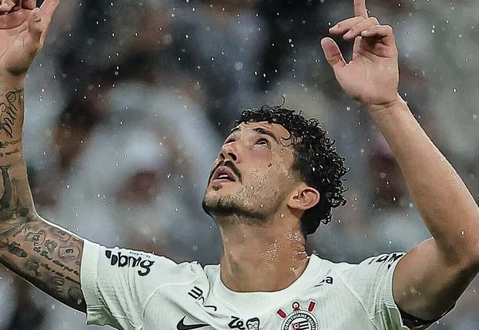 Gustavo Henrique celebra em campo sob chuva, braços erguidos, camisa branca.