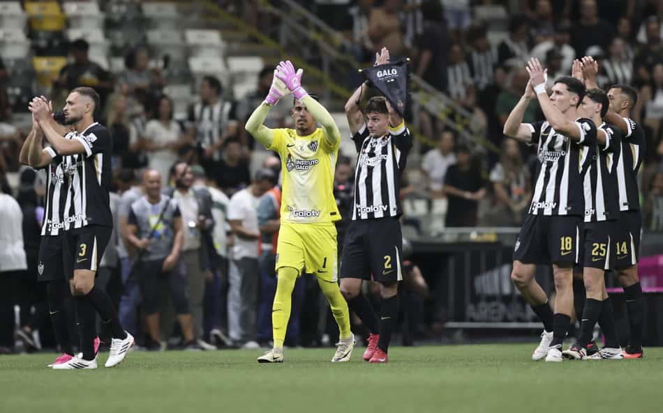 Atlético Mineiro contra Coritiba; goleiro em amarelo aplaude ao lado de seus companheiros em campo.