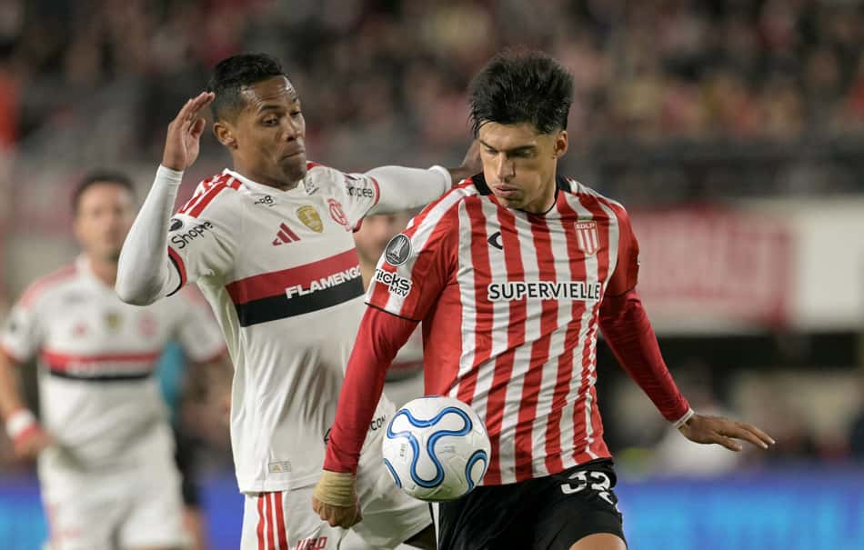 O zagueiro nº 26 do Flamengo Alex Sandro e o atacante nº 32 do Estudiantes Joaquin Correa brigam pela bola durante a partida de ida da semifinal da Copa Libertadores entre o Estudiantes de La Plata da Argentina e o Flamengo do Brasil no estádio UNO Jorge Luis Hirschi em La Plata, província de Buenos Aires, em 15 de outubro de 2026. (Foto: Juan Mabromata / AFP)