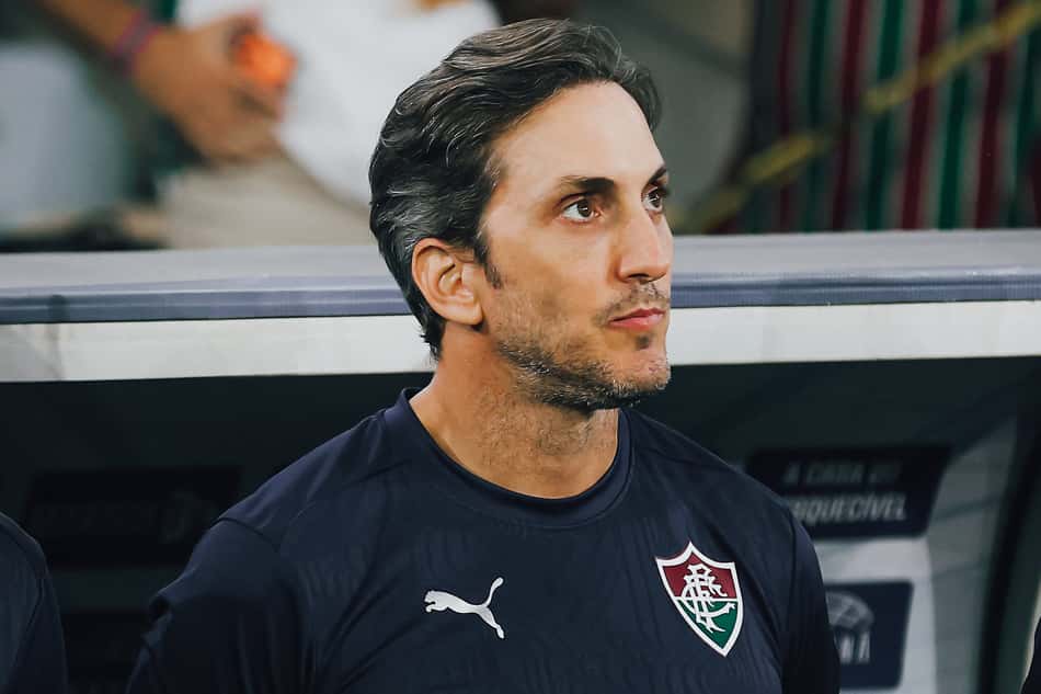 Luis Zubeldía em pé com braços para trás em frente ao banco do Fluminense em duelo com o Vasco