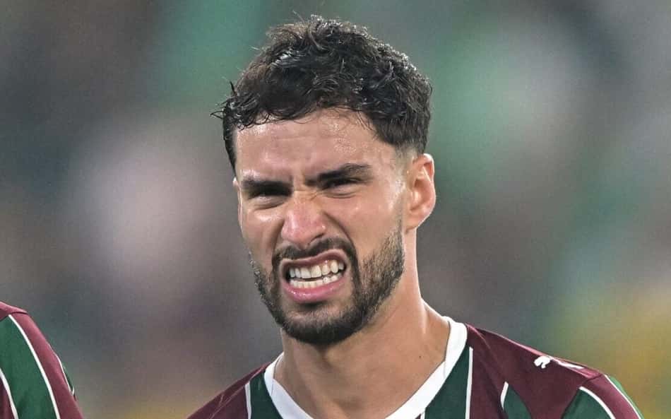 Dois jogadores do Fluminense em campo, com uniformes listrados verde e grená, expressão concentrada.