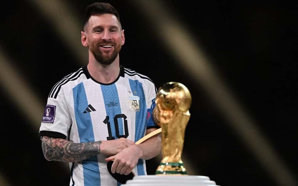 Messi observa troféu da Copa do Mundo conquistada em 2022