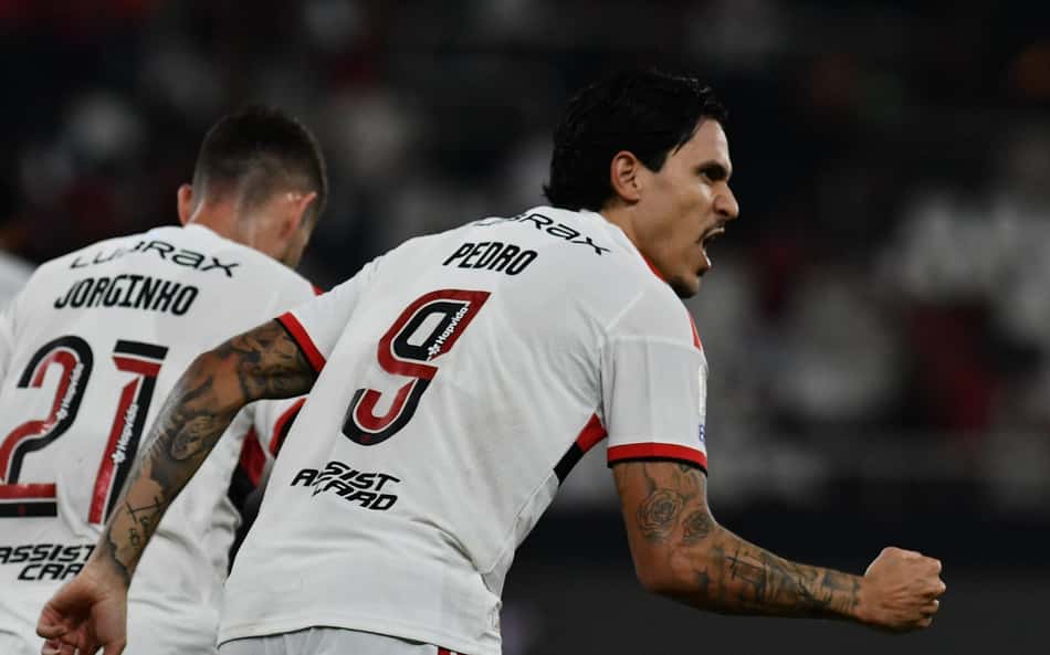 Pedro celebra com Jorginho em campo durante partida de futebol.