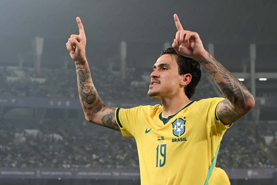 Pedro com a camisa da Seleção Brasileira apontando para cima