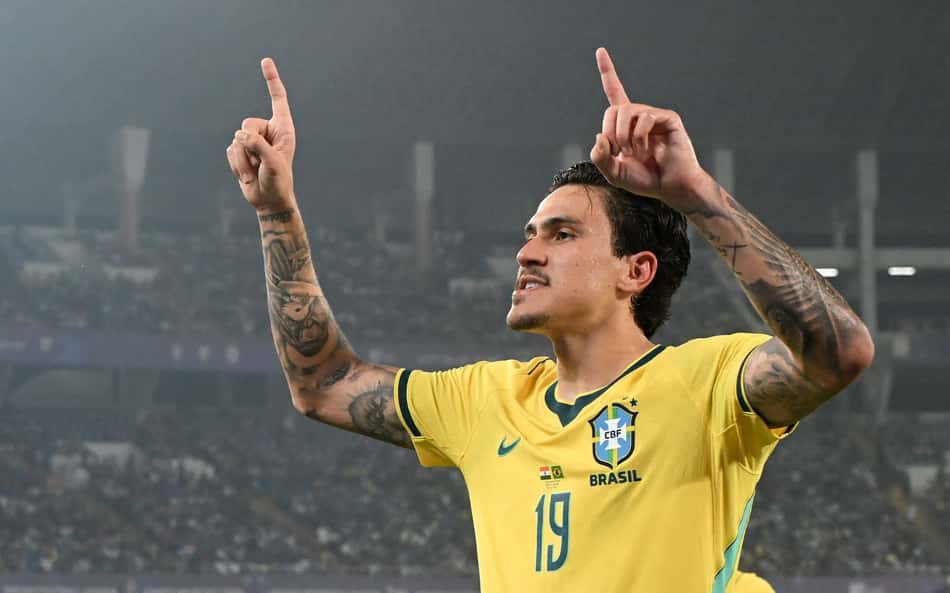 Pedro com a camisa da Seleção Brasileira apontando para cima