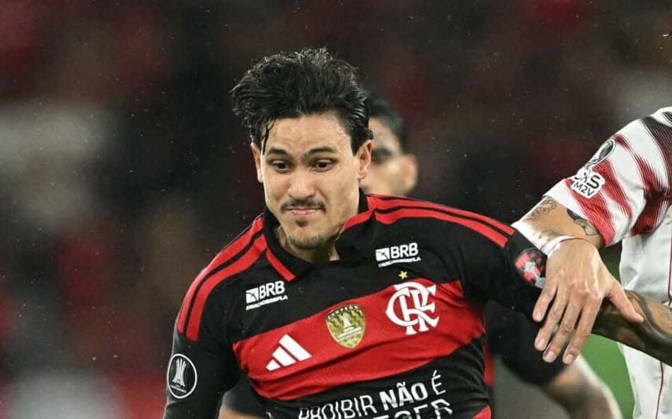 Jogador do Flamengo em drible, cercado por atletas do Estudiantes durante a partida.