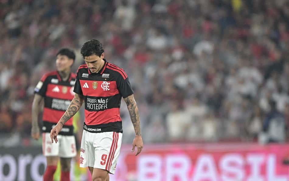 Pedro, atacante do Flamengo, em campo durante partida do Brasileirão, com torcedores ao fundo.