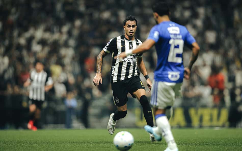 Reinier (Atlético Mineiro) com a bola, em duelo com jogador do time azul durante partida de futebol.
