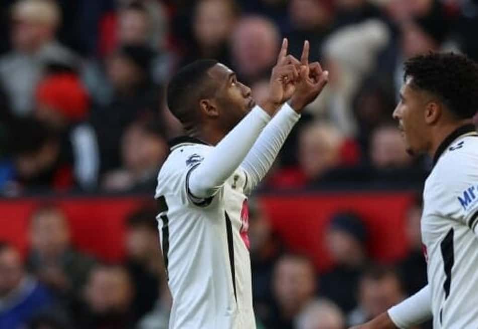 Três jogadores de Bournemouth e Manchester United celebram em campo, com torcida ao fundo.