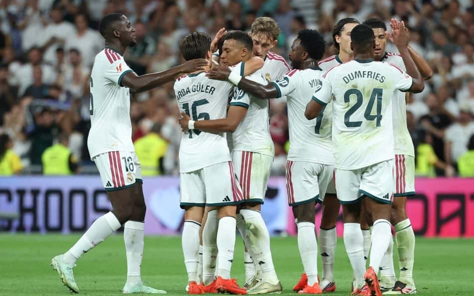 O atacante francês do Real Madrid, camisa 10 Kylian Mbappé (C), comemora com seus companheiros de equipe após marcar o primeiro gol do time durante a partida do Campeonato Espanhol entre Real Madrid CF e Real Sociedad, no Estádio Santiago Bernabéu, em Madri, em 26 de agosto de 2026