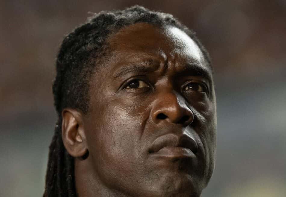 Clarence Seedorf, ex-jogador do Corinthians, em uniforme preto com detalhe laranja, em estádio.