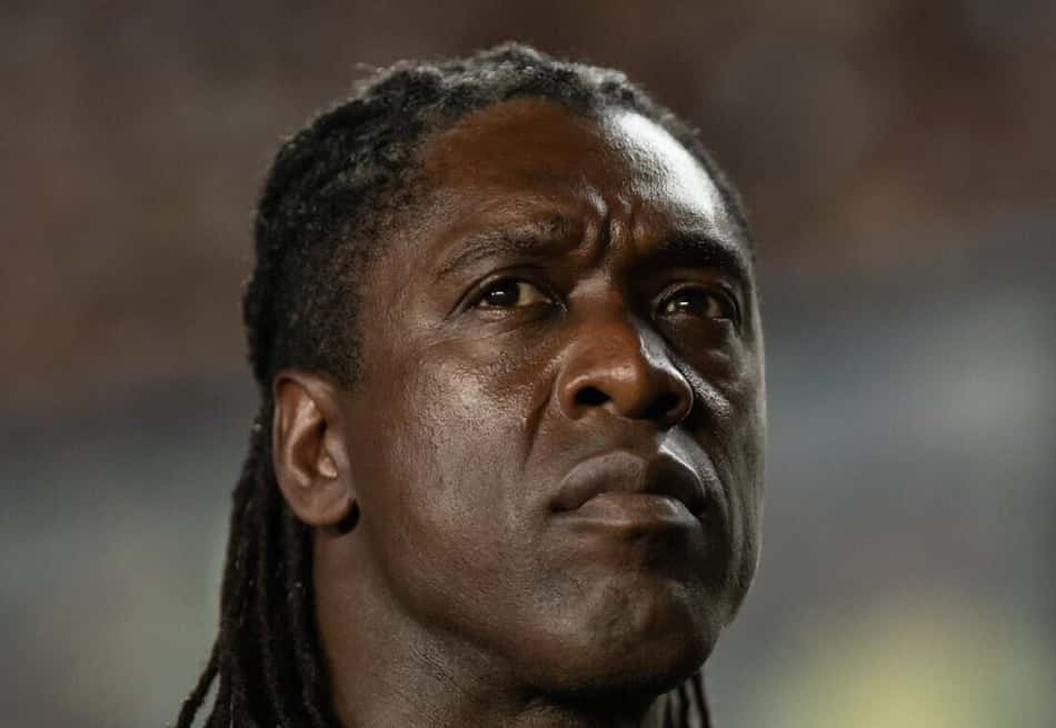 Clarence Seedorf, ex-jogador do Corinthians, em uniforme preto com detalhe laranja, em estádio.