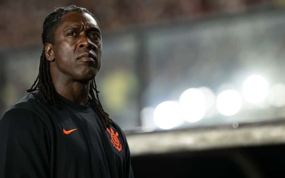 Clarence Seedorf, ex-jogador do Corinthians, em uniforme preto com detalhe laranja, em estádio.