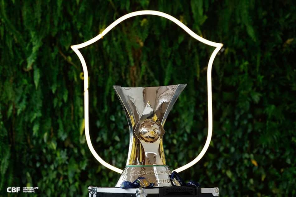 Taça Brasileirão em pedestal prateado, com moldura neon ao fundo e logotipo da CBF.