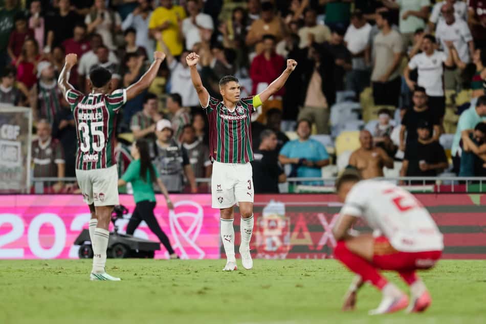 Jogadores do Fluminense celebram a virada sobre o Inter, com torcida ao fundo.