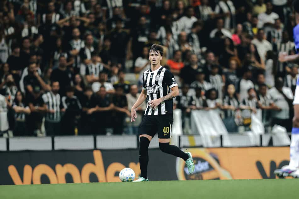Vitão, camisa listrada preto e branco, nº 40, em clássico de futebol, torcida ao fundo.
