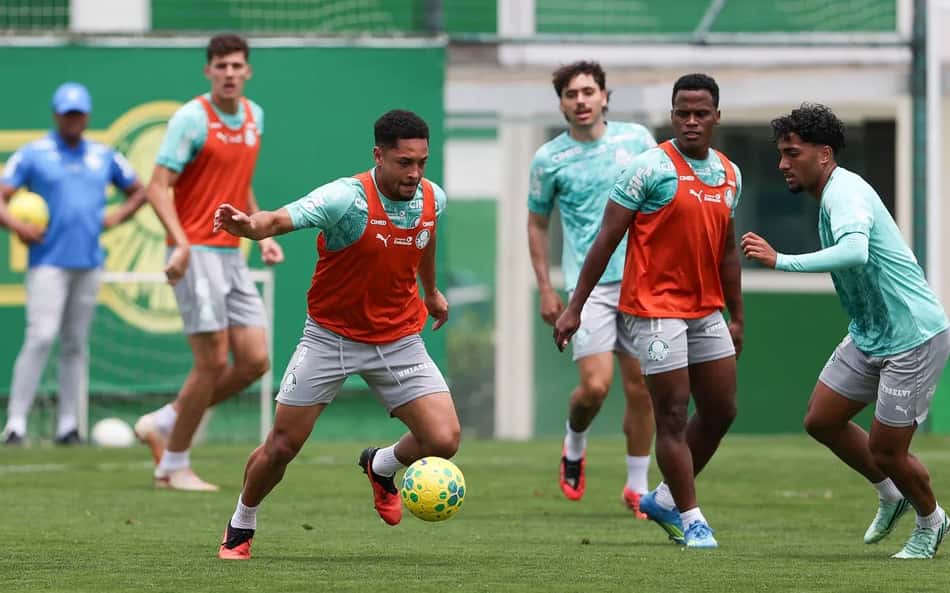 Vitor Roque durante treino do Palmeiras, entre companheiros com coletes laranja e bola.