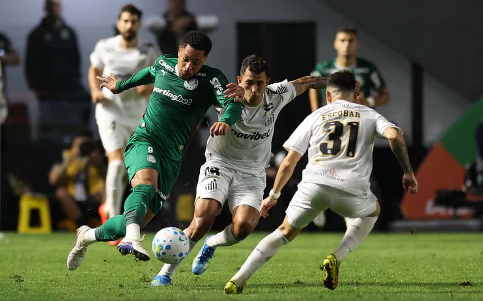 Vitor Roque, do Palmeiras, sofre a marcação de um jogado do Santos