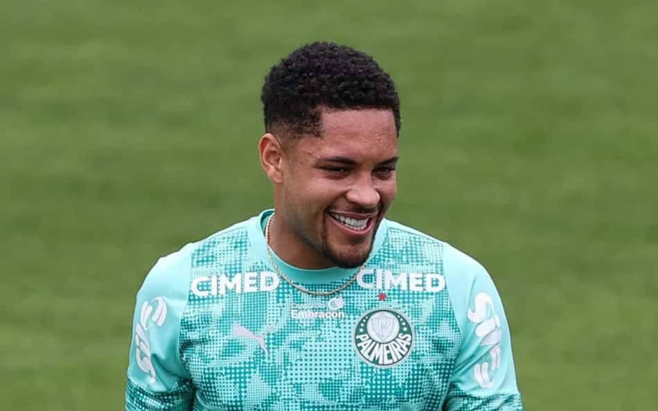 Vitor Roque durante treinamento do Palmeiras, sorrindo, com uniforme verde-água.