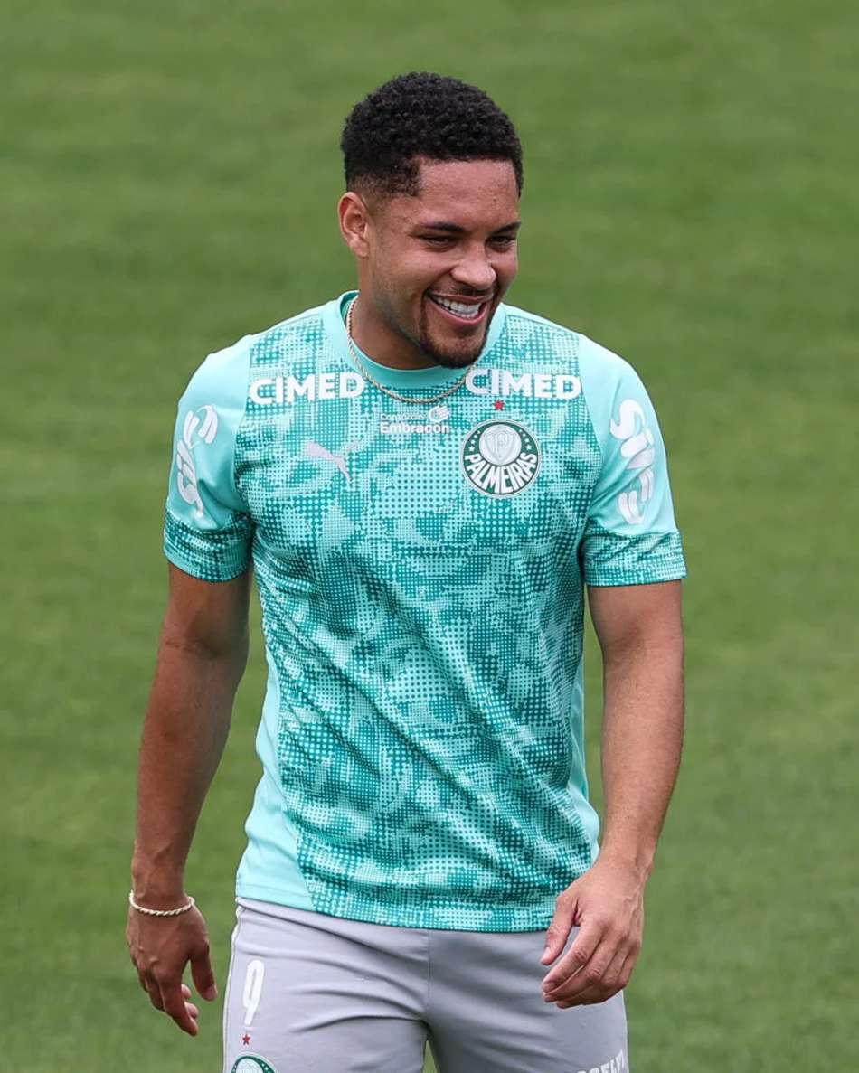 Vitor Roque durante treinamento do Palmeiras, sorrindo, com uniforme verde-água.