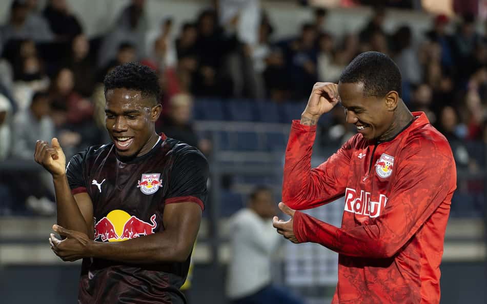 Wallace e Yan, jogadores do Red Bull, celebram durante partida de futebol em estádio.