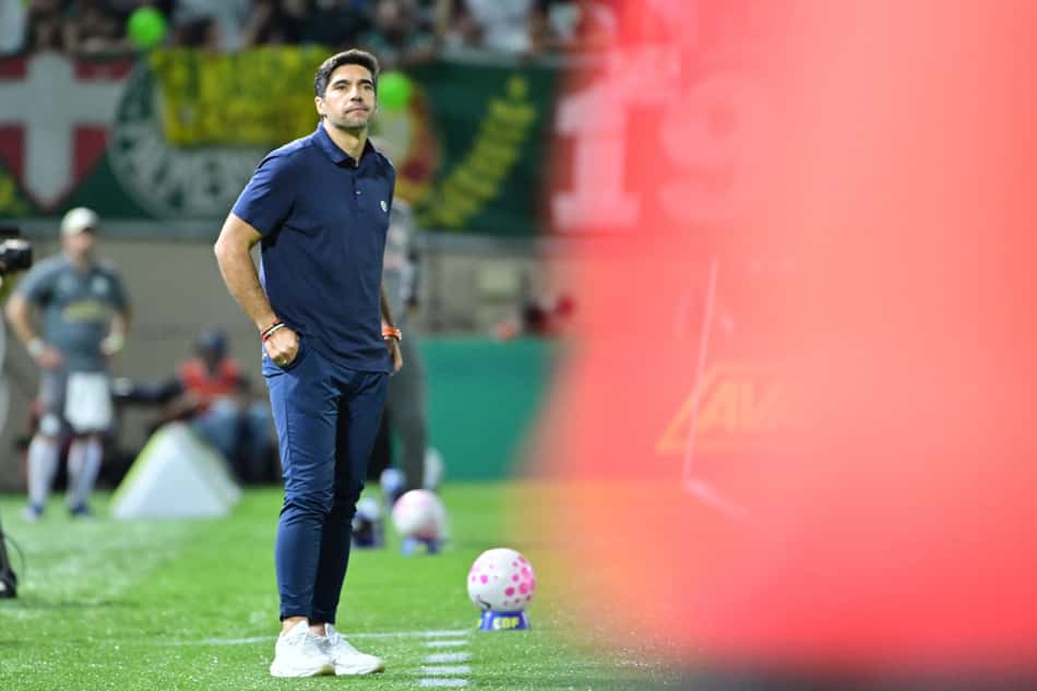 Treinador do Palmeiras em campo durante partida de futebol.