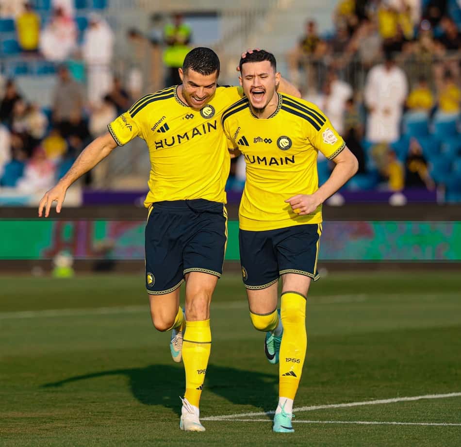 Dois jogadores do Al Nassr comemoram gol em partida de futebol.
