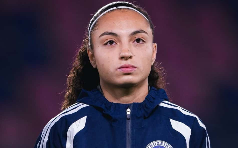 Ana Flávia, jogadora do Cruzeiro Esporte Clube, em casaco azul com o emblema do clube.
