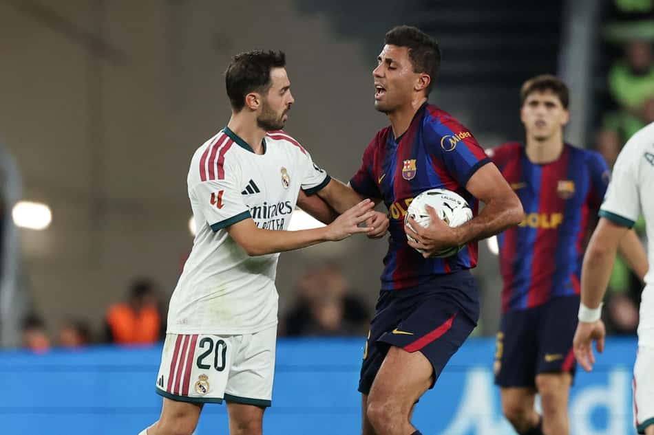 Jogadores do Real Madrid e do Barcelona disputam a bola durante a partida.
