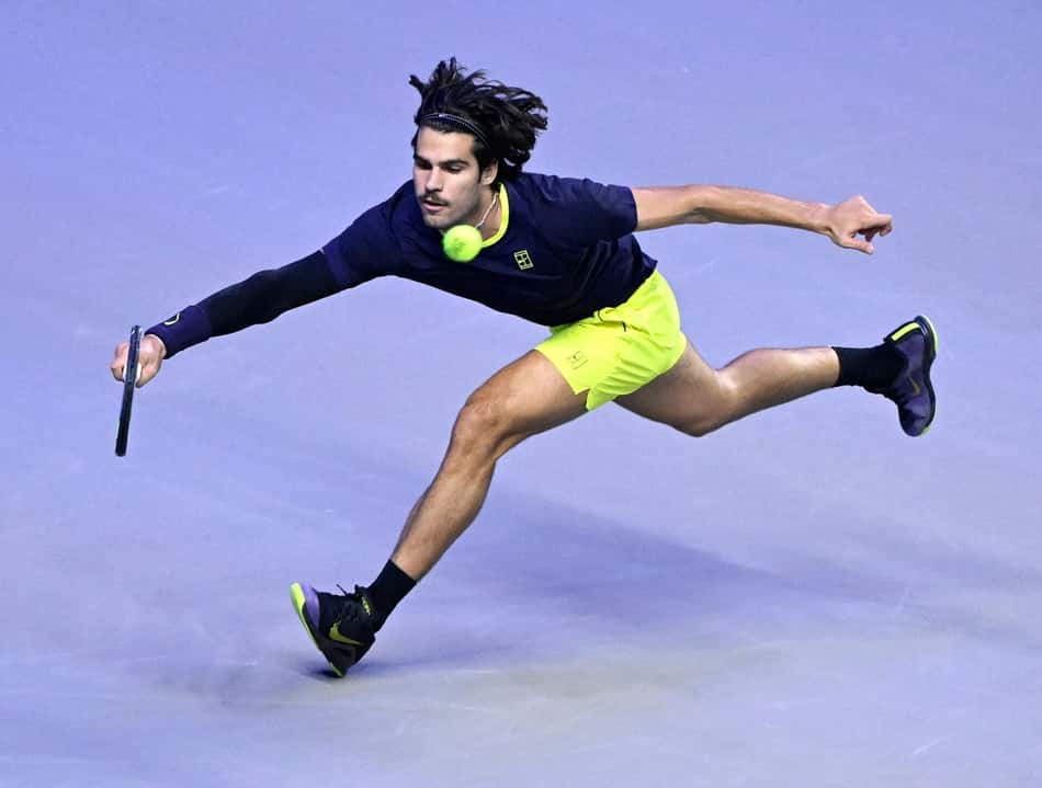 Carlos Alcaraz em ação no ATP de Viena, mergulhando para devolver a bola.