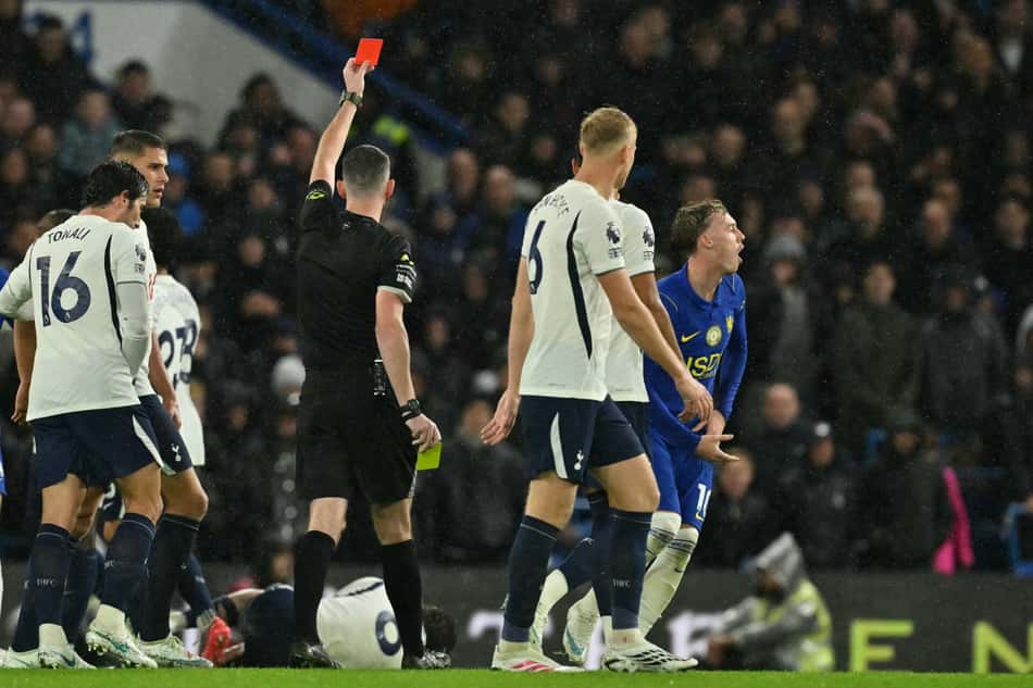 Cole Palmer expulso em Chelsea x Tottenham, árbitro ergue cartão vermelho; torcedores ao fundo.