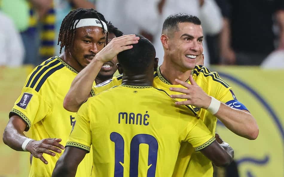 O atacante português do Al-Nassr, número 7, Cristiano Ronaldo, comemora com o atacante senegalês do Al-Nassr, número 10, Sadio Mané, após marcar o segundo gol de sua equipe durante a partida do Grupo B da Liga dos Campeões da AFC entre Al-Nassr e Neftchi Fergana, no estádio Alawwal Park, em Riade, em 12 de outubro de 2026 (Foto: Fayez Nureldine / AFP)