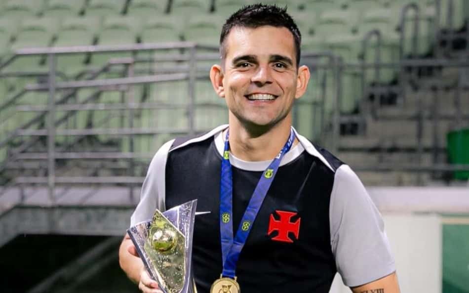 Matheus Curopos com troféu e medalha em estádio vestindo uniforme preto com detalhe branco