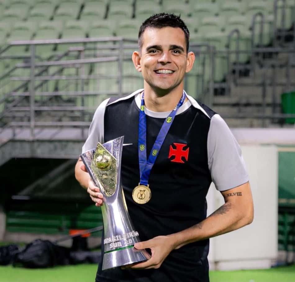 Matheus Curopos com troféu e medalha em estádio vestindo uniforme preto com detalhe branco