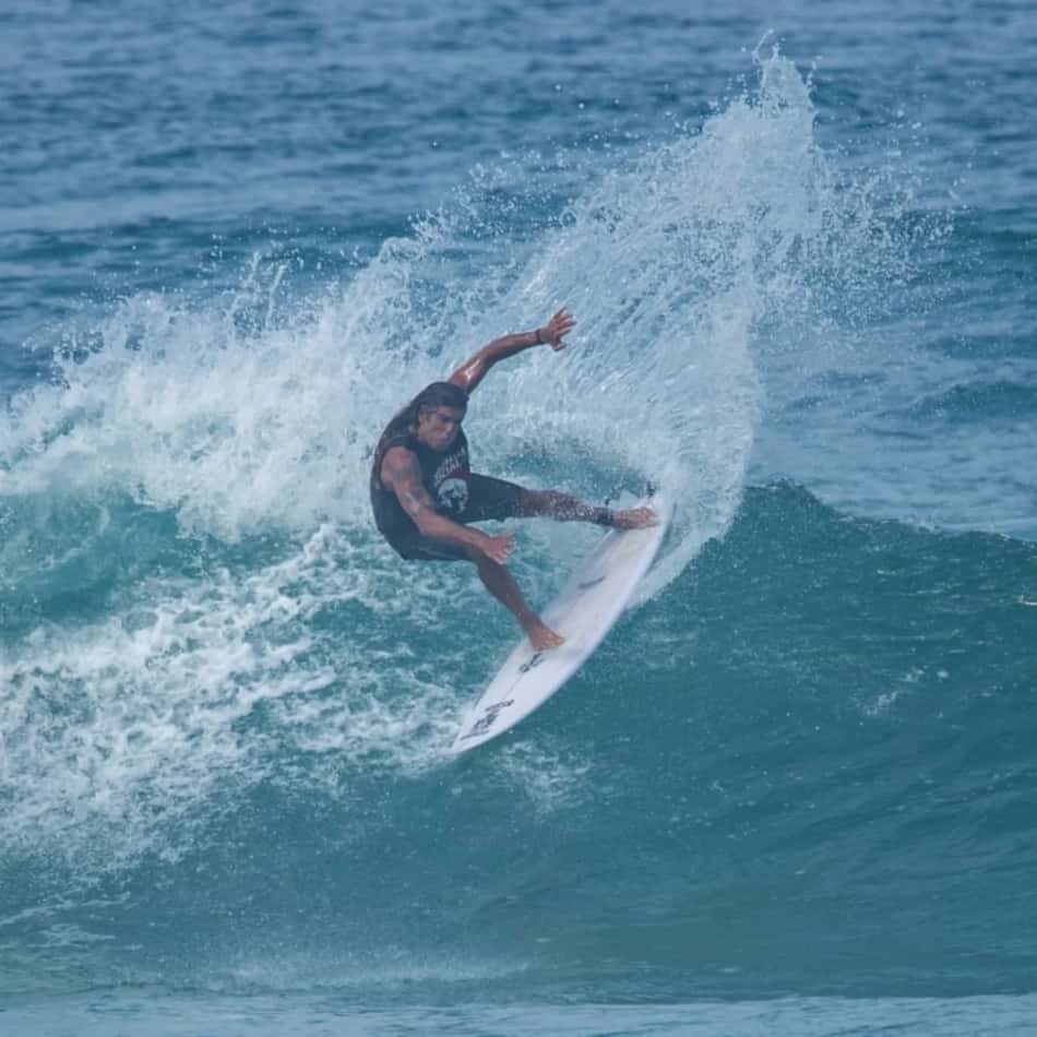 Dadá Figueiredo surfando uma onda, executando manobra com spray de água.