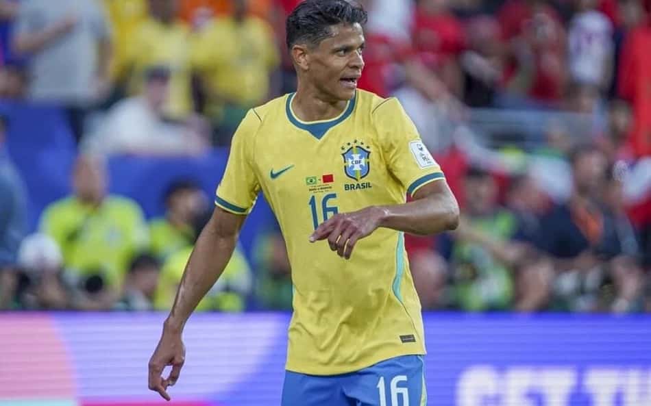 Jogador brasileiro em camisa amarela nº16 durante partida, com o escudo da CBF visível e torcida ao fundo.