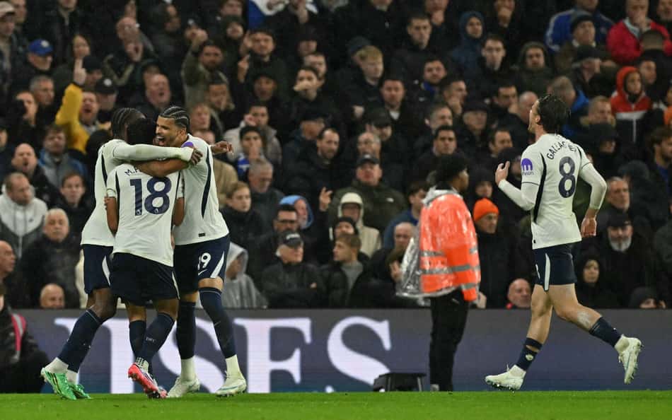 Tottenham Hotspur comemora gol em campo, com torcida ao fundo.