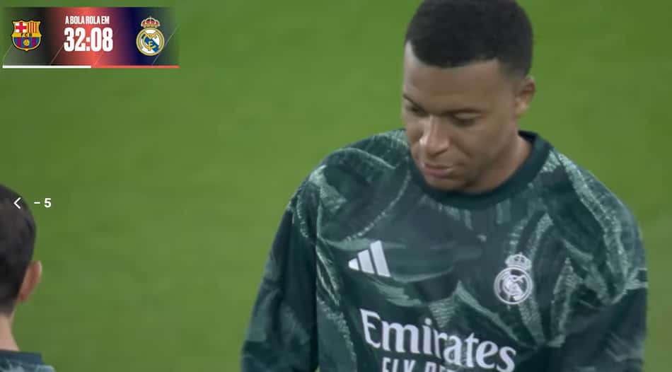 Goleiro do Real Madrid em clássico contra o Barcelona, uniforme verde, em campo, placar 32:08 no banner superior.