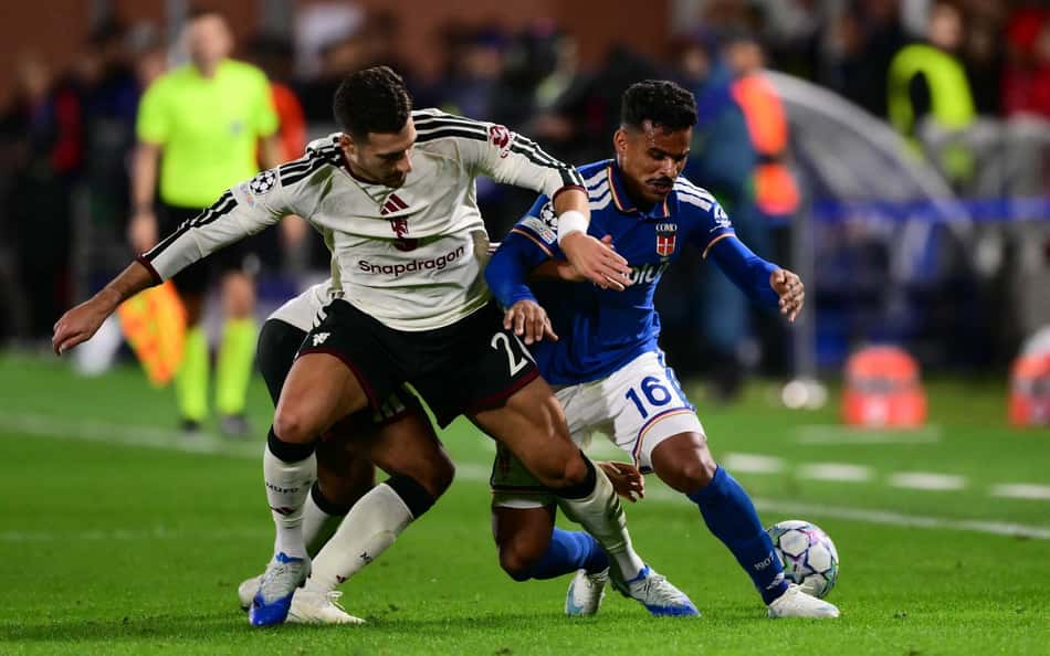 Kaiki Bruno, do Como, disputa a bola com Diogo Dalot, do Manchester United, durante partida da Champions League.