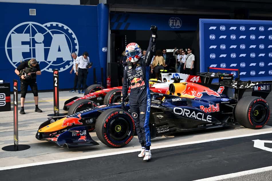 Max Verstappen ergue o punho esquerdo, em frente ao carro da Red Bull, em comemoração à primeira pole position do ano no GP do Bahrein