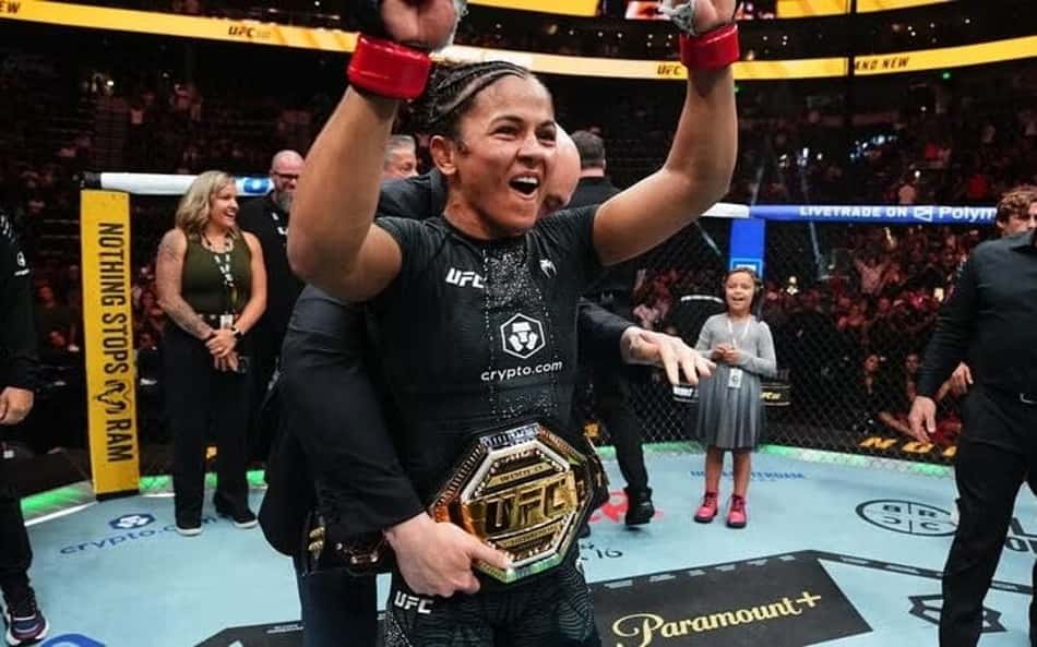 Natália Silva ergue os braços enquanto tem o cinturão do UFC colocado por Dana White