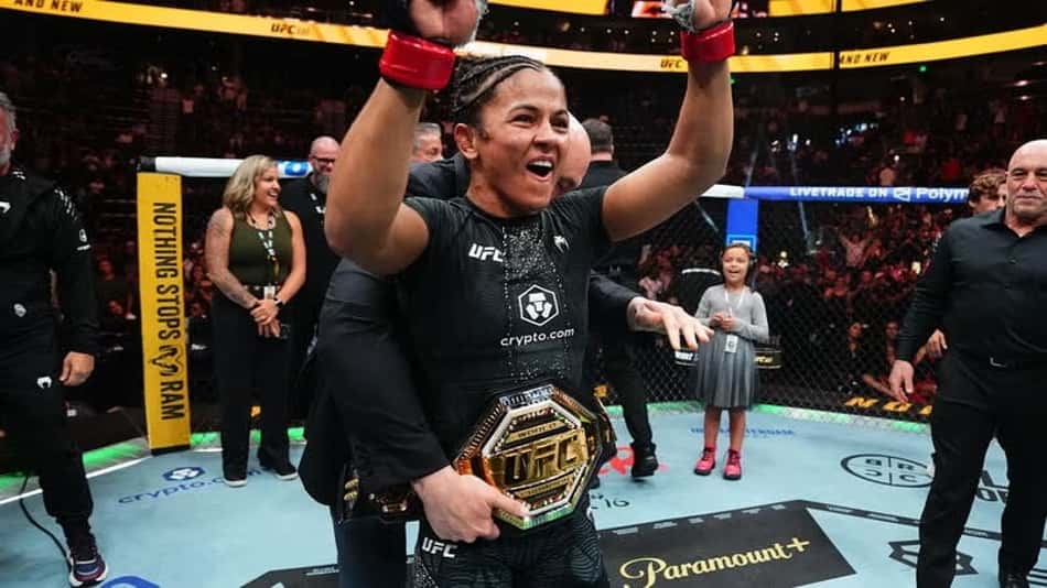 Natália Silva ergue os braços enquanto tem o cinturão do UFC colocado por Dana White