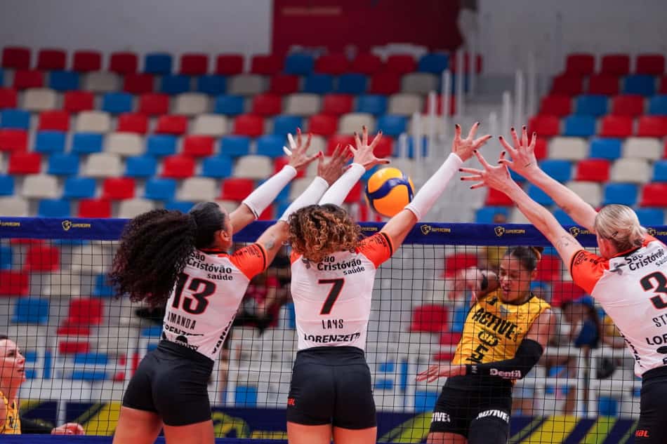 Jogadoras do Osasco São Cristóvão Saúde bloqueiam na rede contra Praia Clube na Supercopa de Vôlei